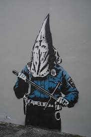 Mural urbain KKKOP de Goin photographie en rue, vue large avec potelets.